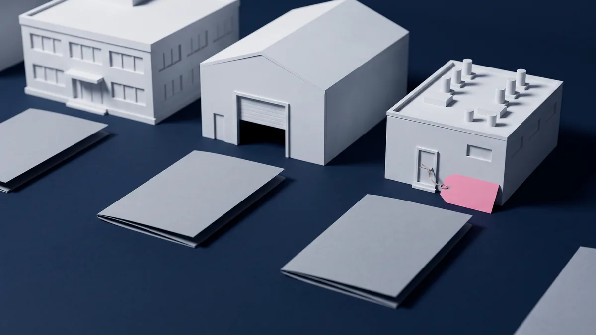Three white architectural scale models of an office block, a warehouse and a small laboratory on a navy table, each with an identical blank grey folder in front, and a blank pink tag tied only to the laboratory door.