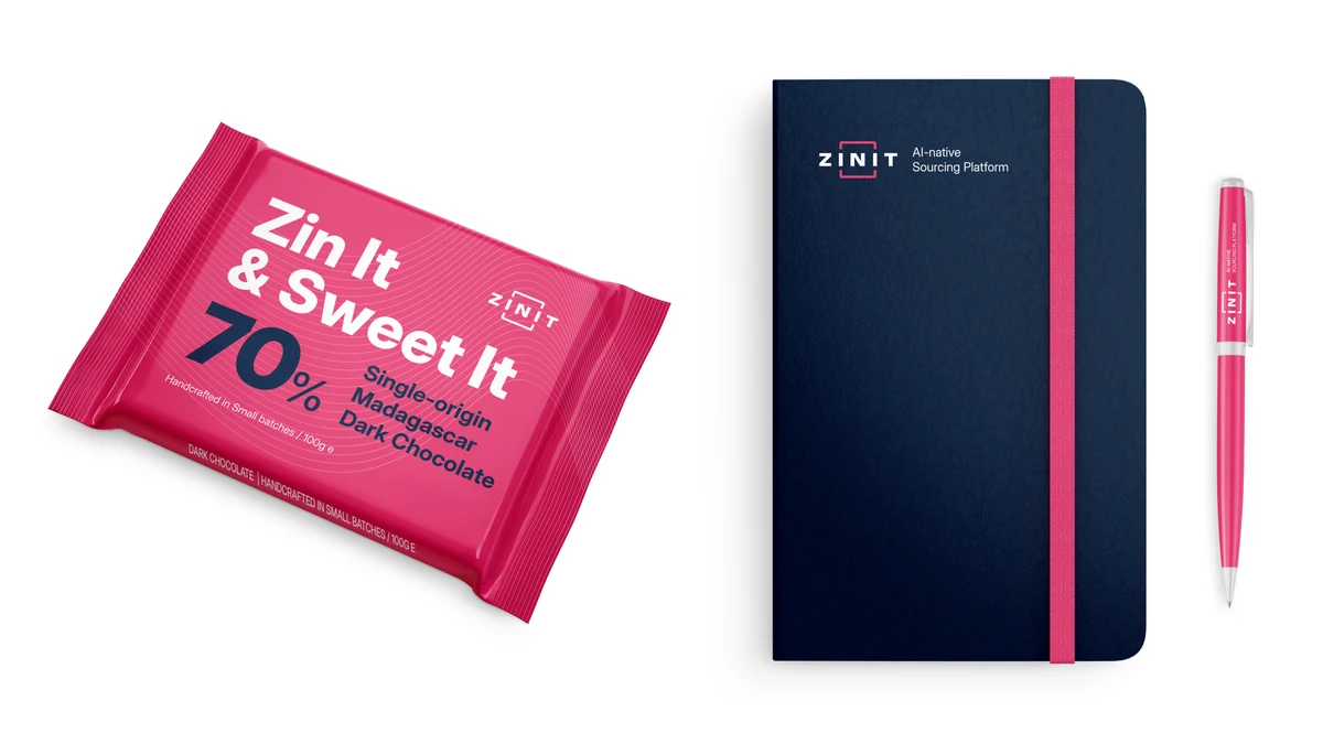 A branded chocolate bar reading “Zin It & Sweet It”, beside a navy notebook and a raspberry pen.